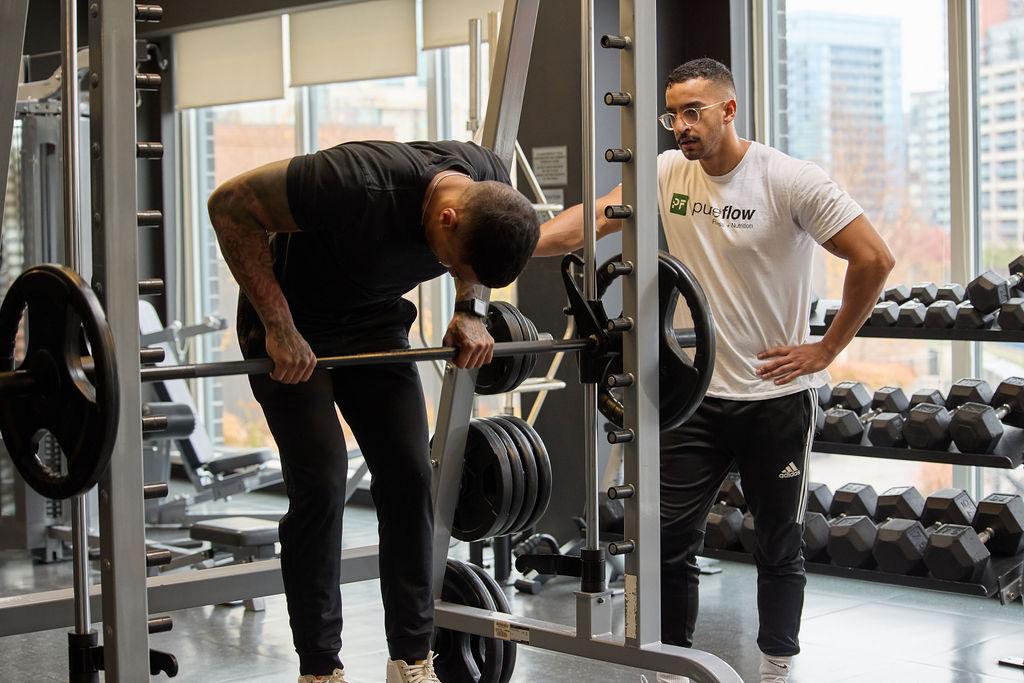 Coach Mo training a client with barbell